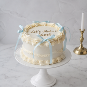 Tort aniversar alb vintage cu fundițe bleu și mesaj personalizat